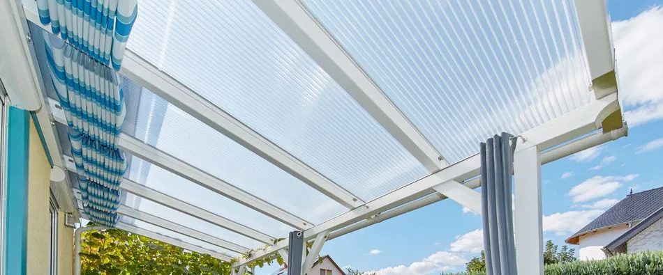 Terrassenüberdachung mit Stegplatten aus Polycarbonat in klar und einer Beschattung aus Stofflagen
